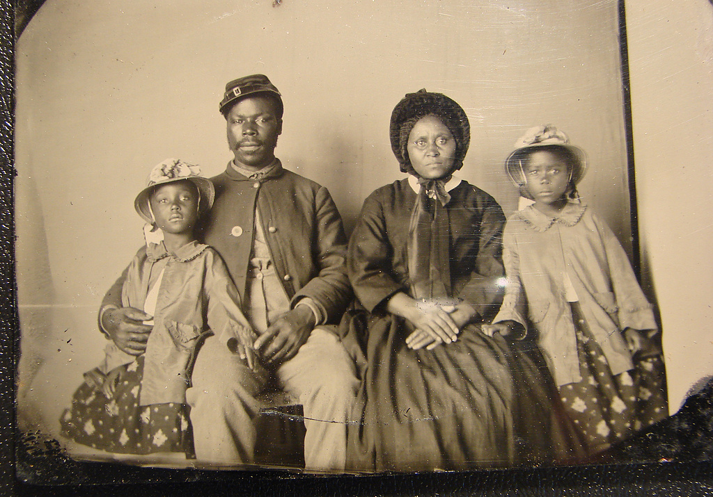 Unidentified African American soldier in Union uniform with wife and two daughters, c. 1863-1865